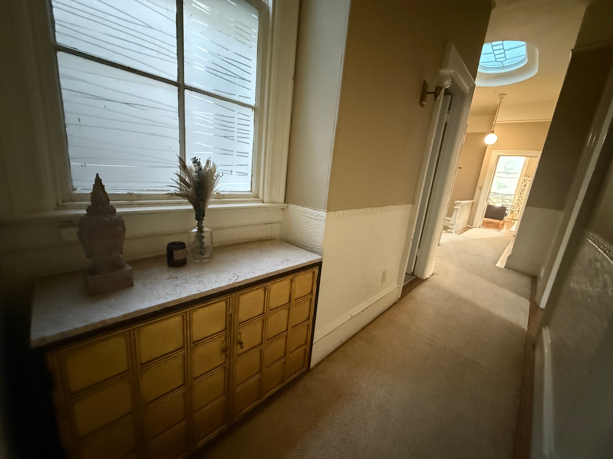 Hallway with vintage yellow dresser and Buddha statue