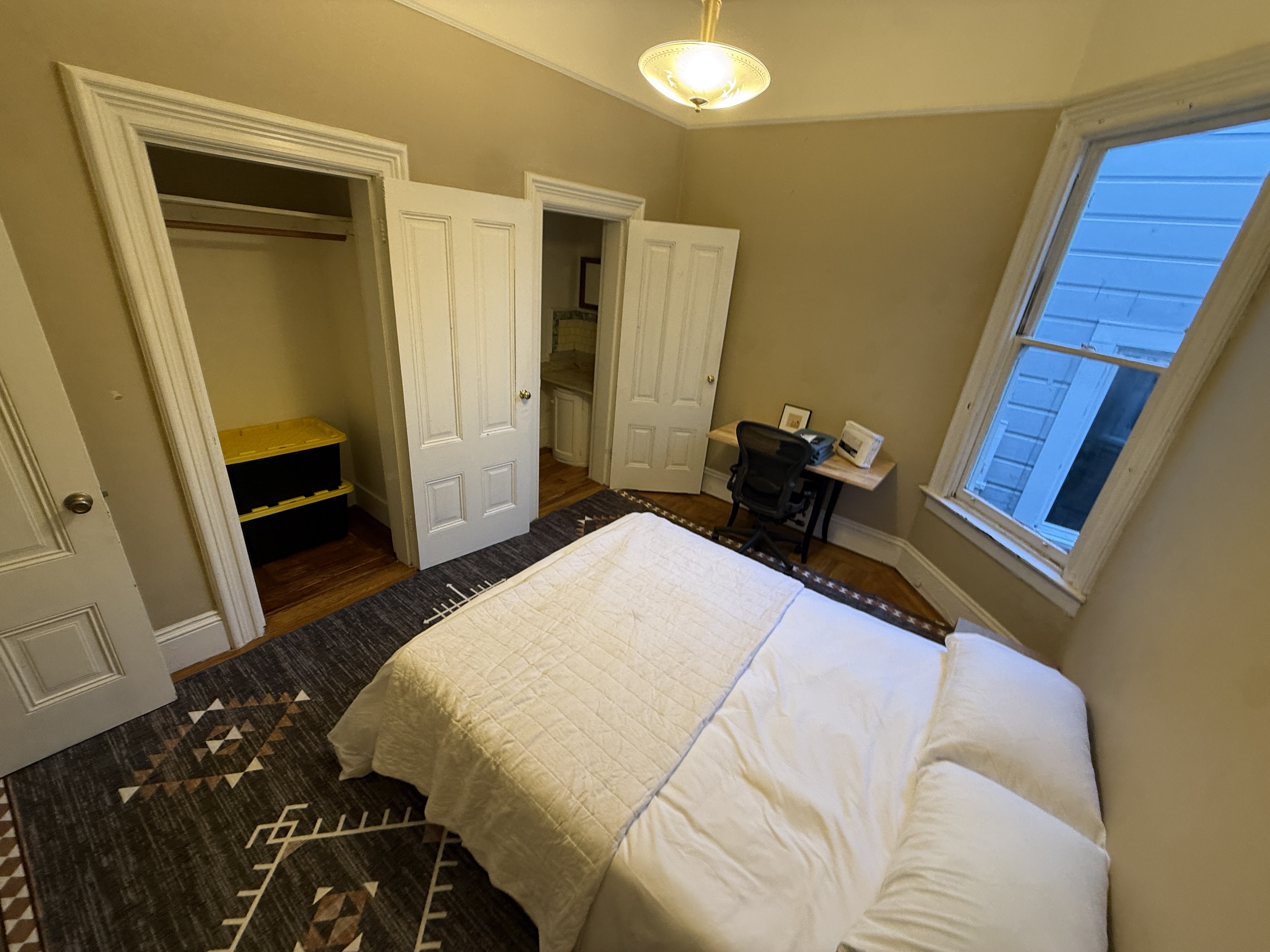 Bedroom with desk and closet with yellow shelving