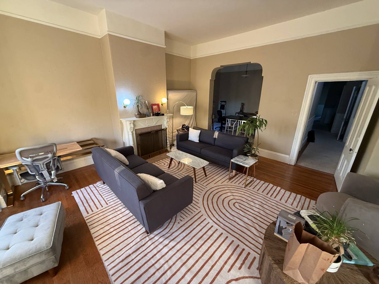 Living room showing two couches, striped rug and archway to dining