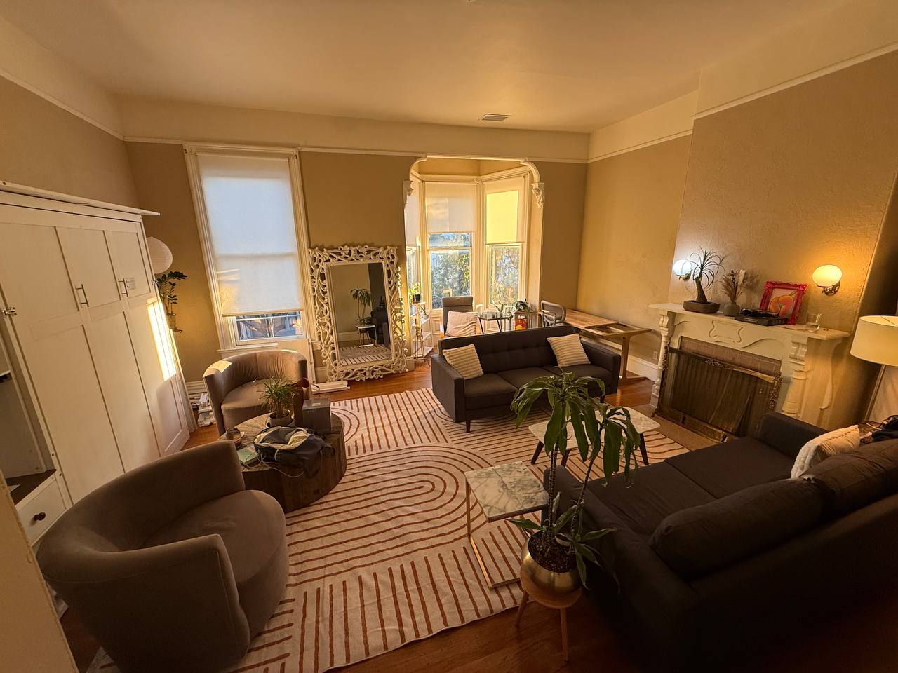 Evening view of living room with white wardrobe and ornate mirror